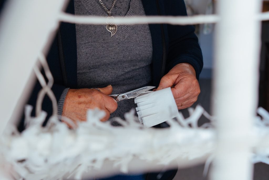 Cortando os enfeites de papel para o altar